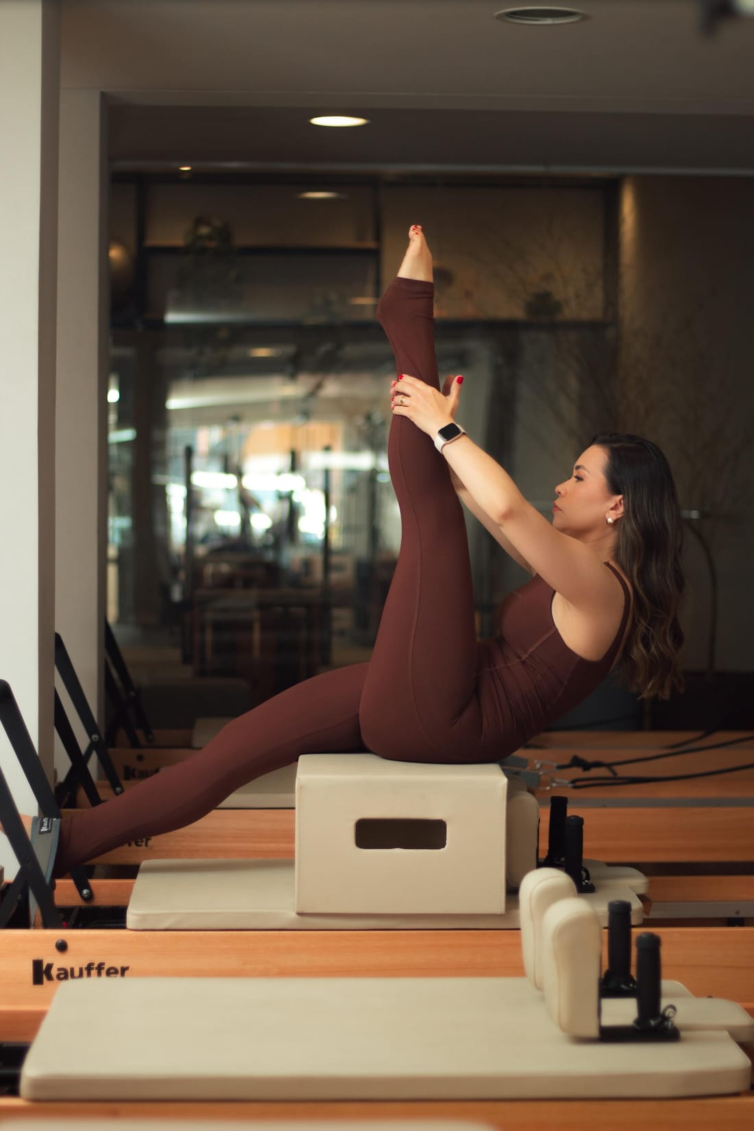 Ana praticando pilates no reformer do estúdio